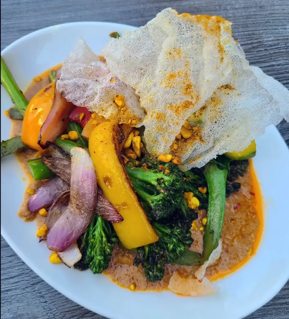 Plant-based vegetables and crisp garnish on a plate at Fat Choi