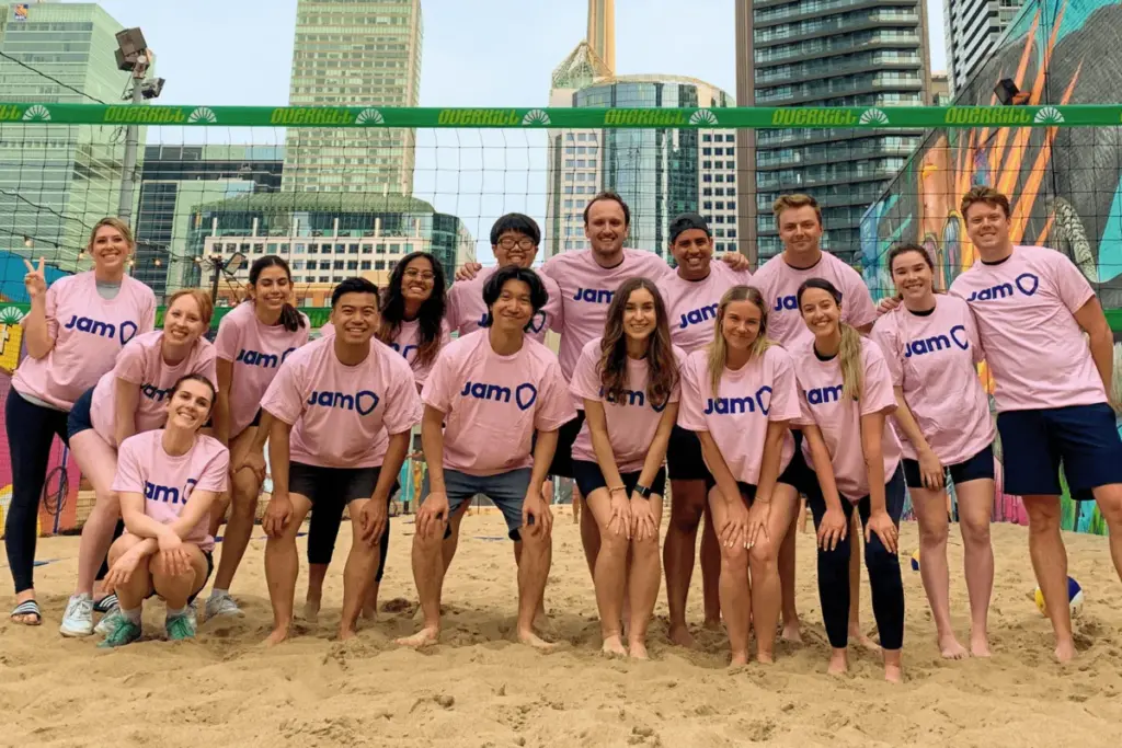 Diverse adult volleyball group in pink JAM Sports shirts smiling in Toronto