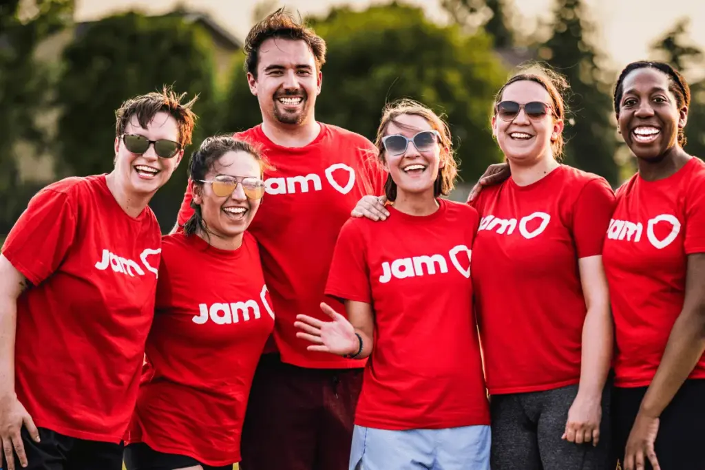 Mostly women recreational sports team smiling together in red JAM Sports shirts