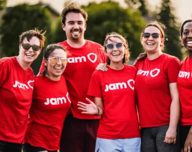Mostly women recreational sports team smiling together in red JAM Sports shirts
