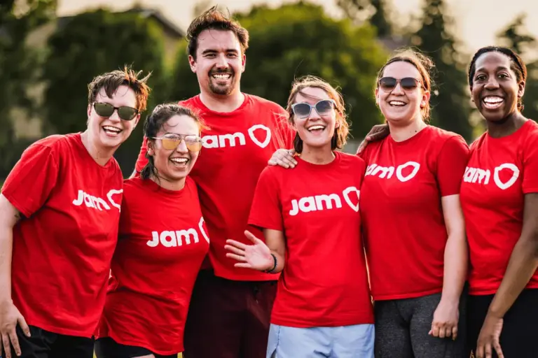 Mostly women recreational sports team smiling together in red JAM Sports shirts