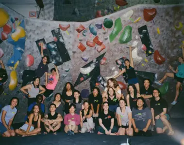 Womens bouldering group posing inside True North Climbing in Toronto