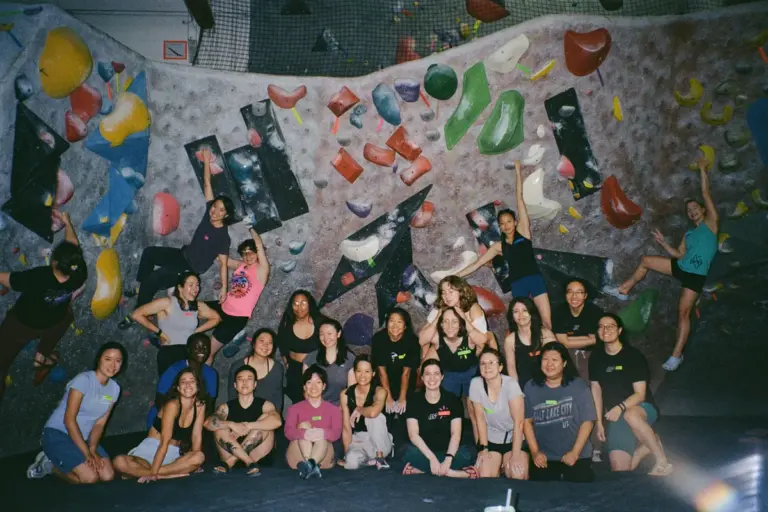 Womens bouldering group posing inside True North Climbing in Toronto