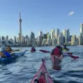 Group kayaking on Toronto Harbour with the CN Tower and skyline ahead