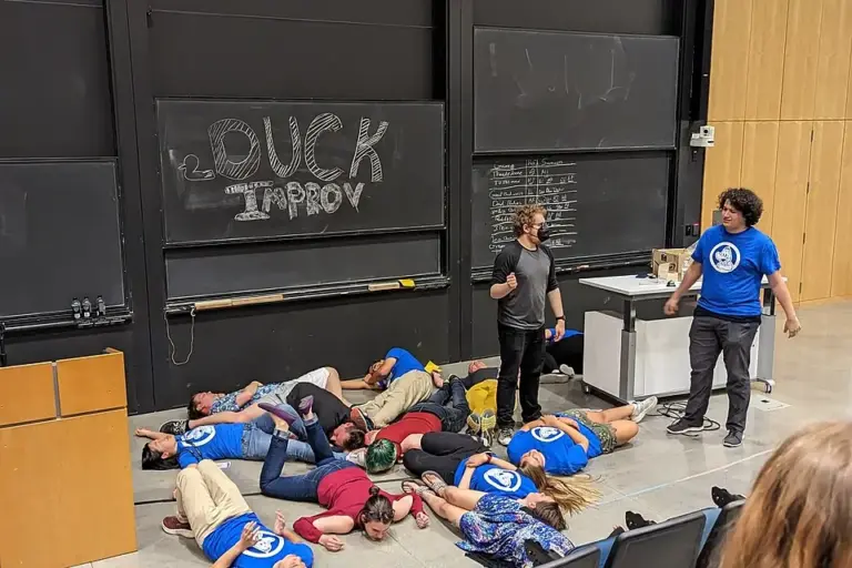Improv performers acting out a comic scene onstage