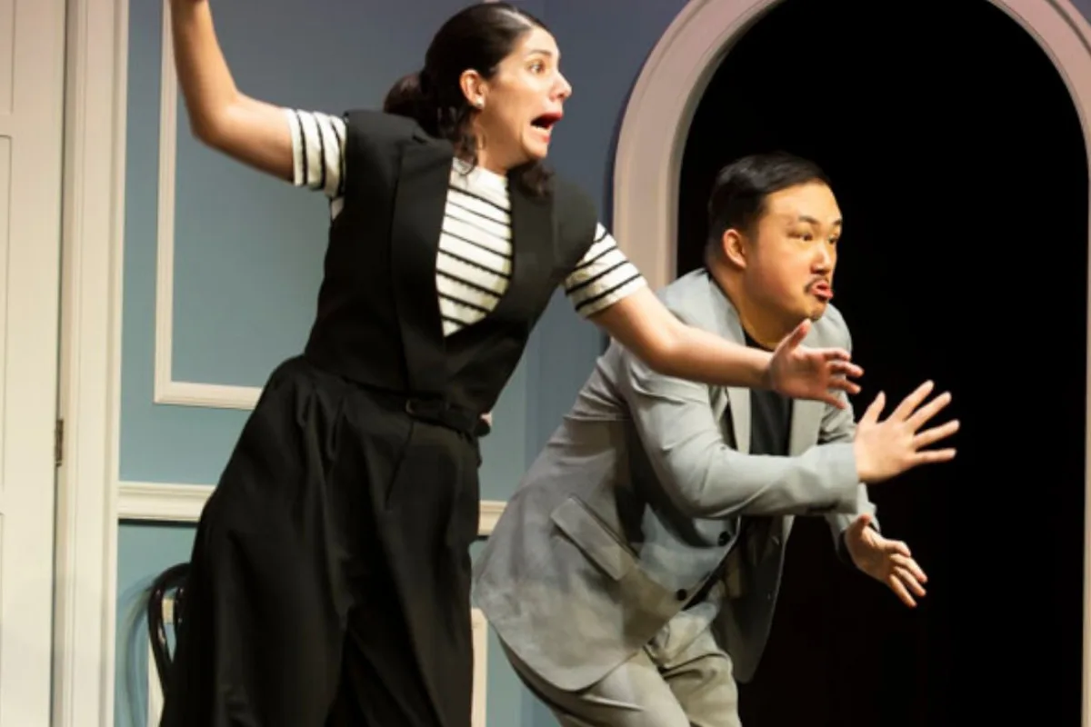 Two Second City Toronto performers acting out a lively scene onstage
