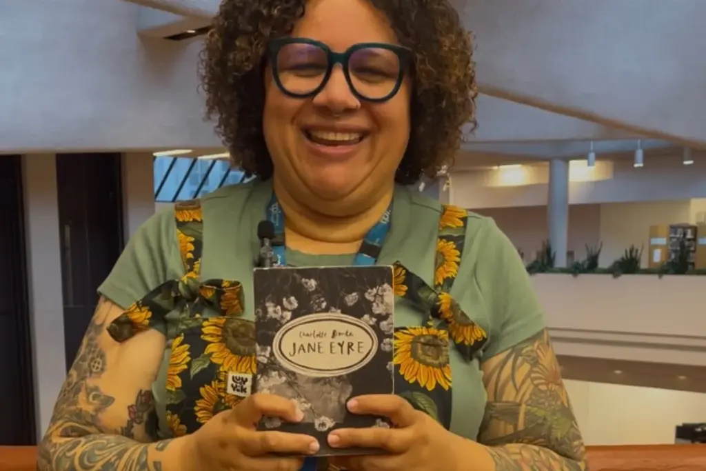 Smiling Toronto Public Library staff member holding a copy of Jane Eyre