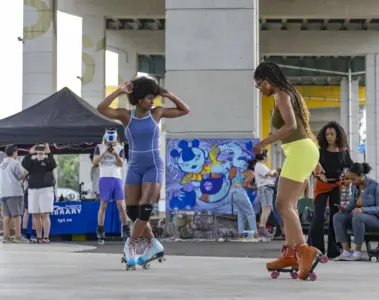 Two women roller skating and dancing together at The Bentway in Toronto