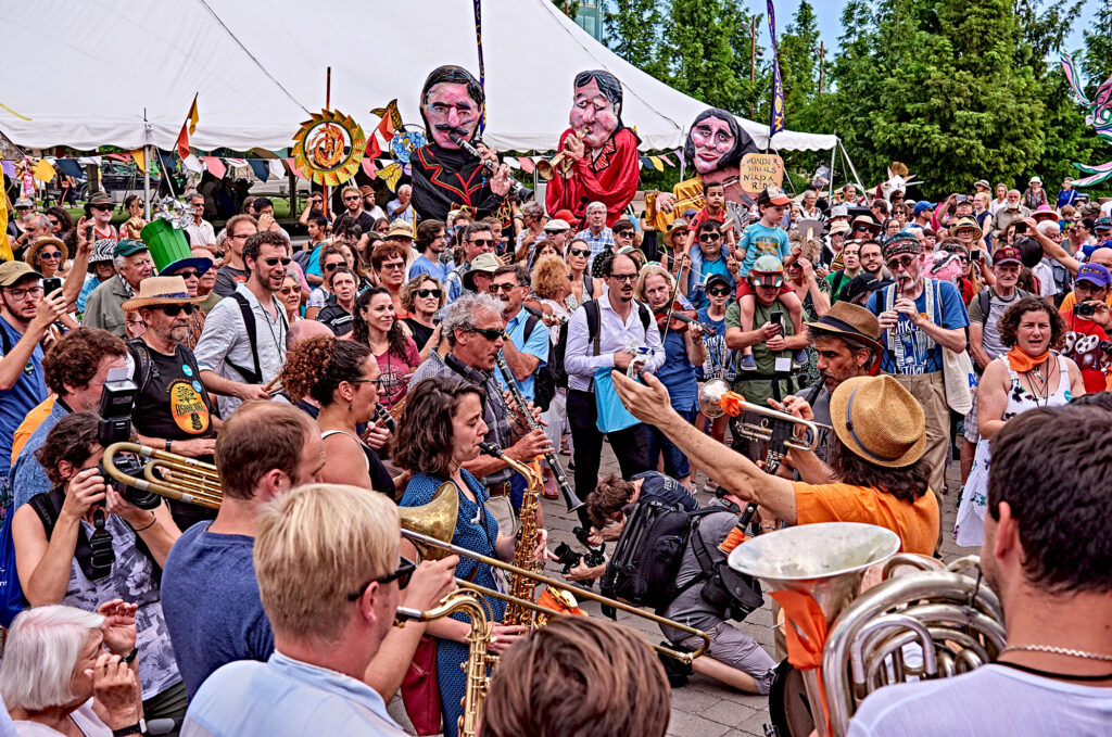 Musicians, giant puppets and a large crowd at the Ashkenaz Festival parade in Toronto