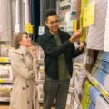 Couple comparing quilted bedding and price labels in a store