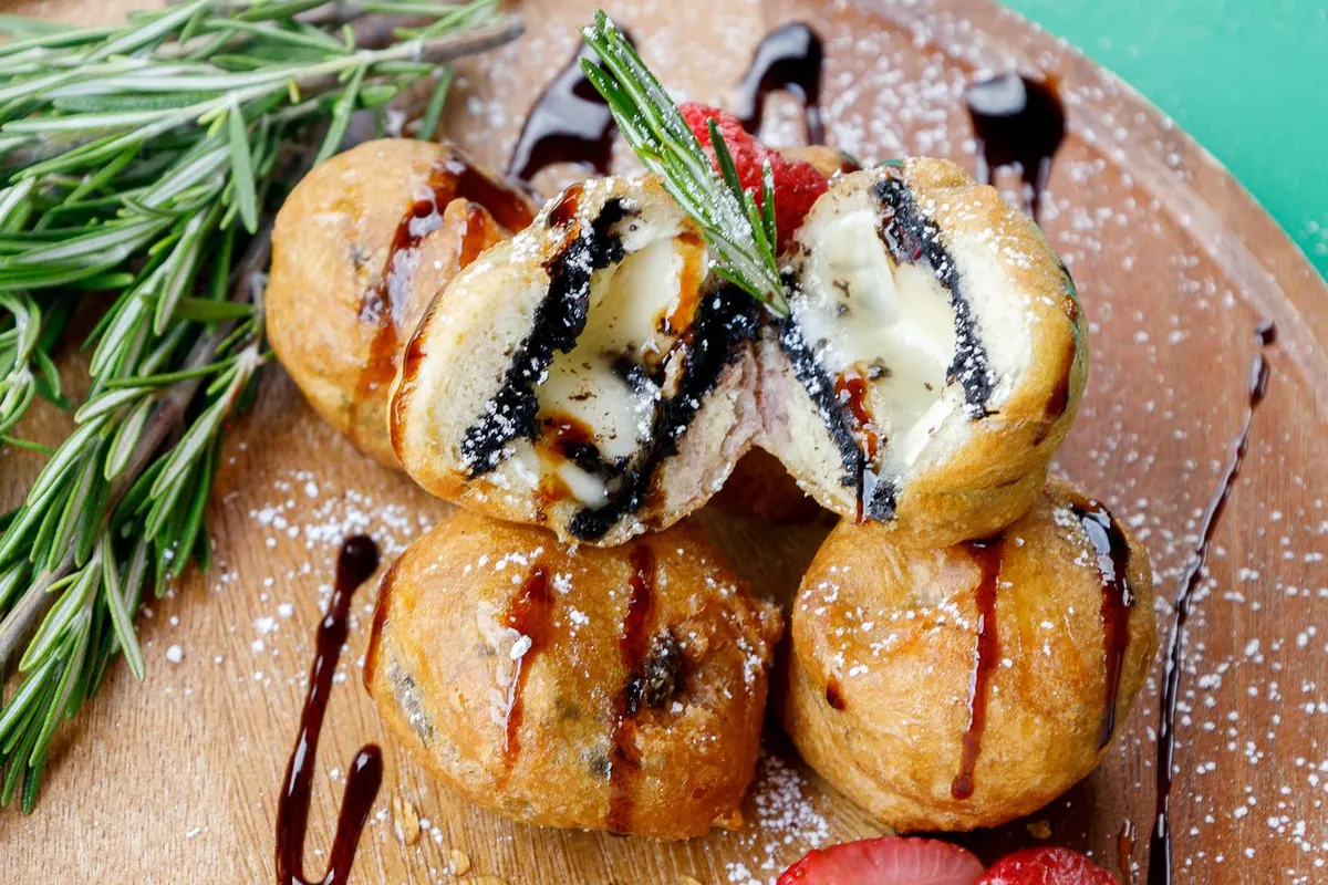 Deep fried Oreo cookies filled with Brie cheese and topped with rosemary