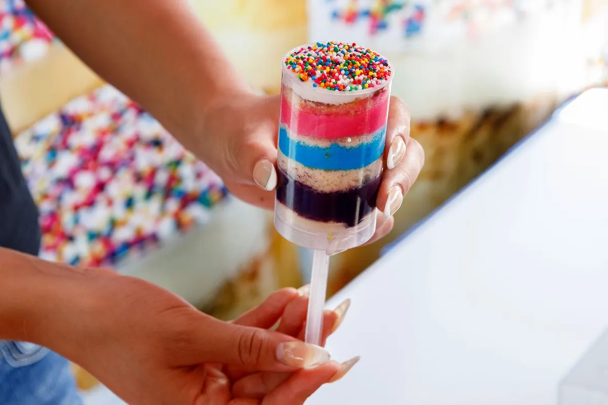 Colourful dot cake pieces layered inside clear push-pop tubes