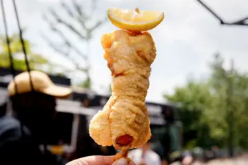 Tempura lobster tail on a stick with dill sauce and lemon