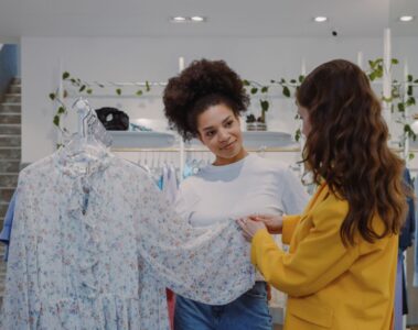 Two women looking at a floral dress inside a boutique