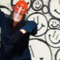 A woman in a hard hat and face shield raises a crowbar inside Chaos Studios