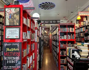 Red shelves packed with used books inside Re:Reading