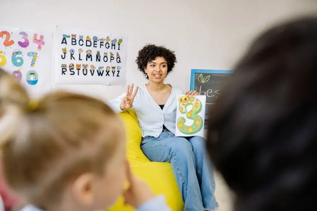 Early childhood educator sitting with children during a classroom activity