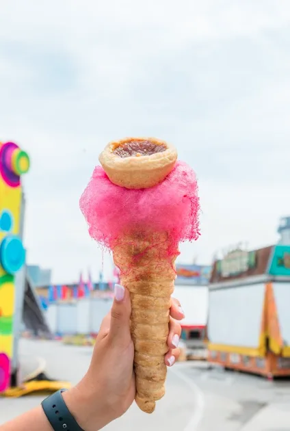 Pink cotton candy wrapped around a pastry cone topped with a butter tart at the CNE
