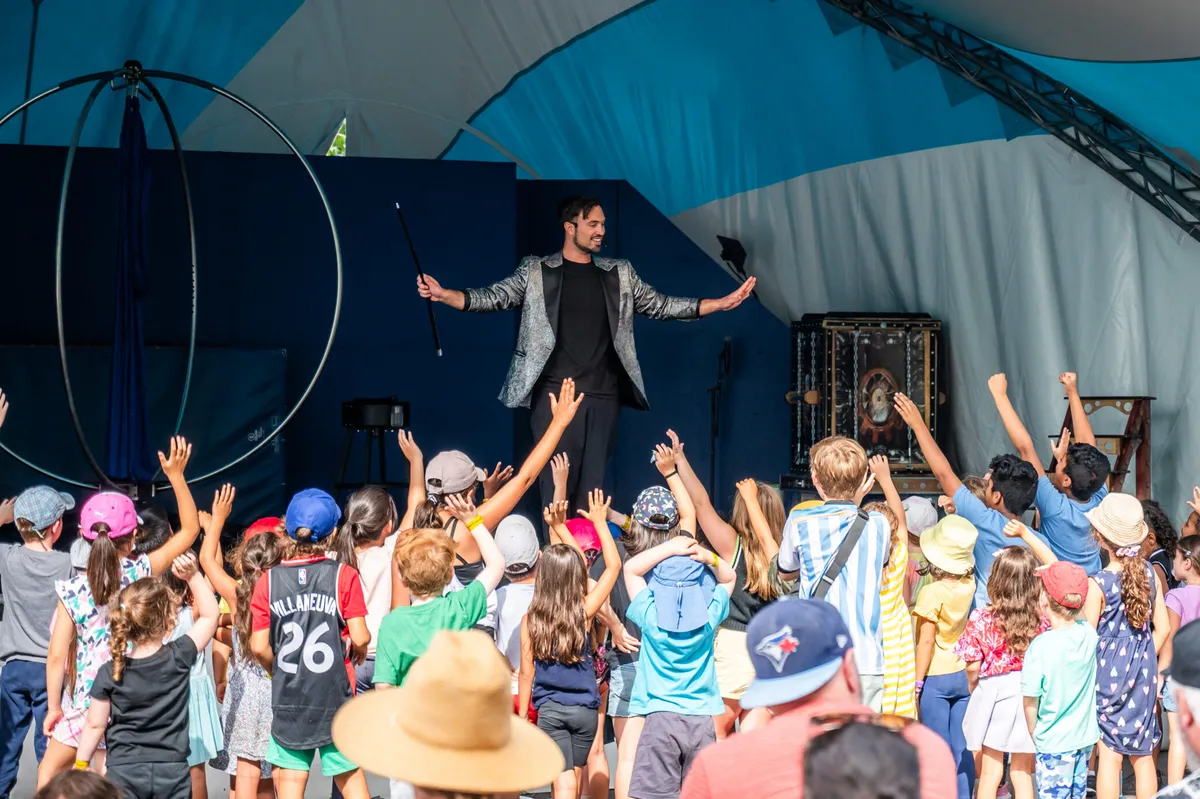 Children watching a live performer on the Kids World stage at the CNE