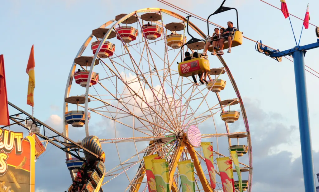 CNE Sky Ride passing the Ferris wheel on a bright day
