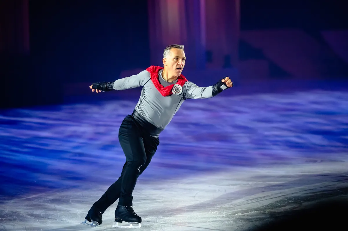 Figure skater performing under blue lights at the CNE ice show