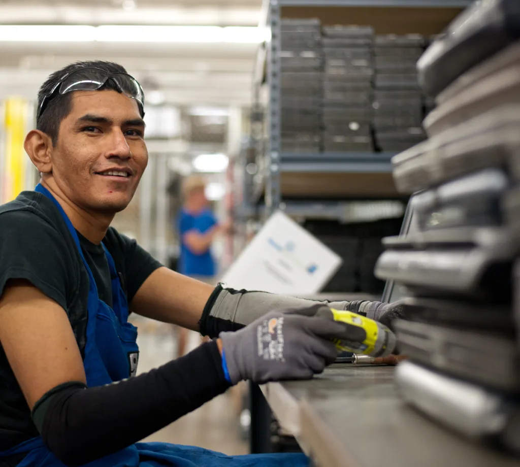 A worker sorting donated electronics for reuse and recycling
