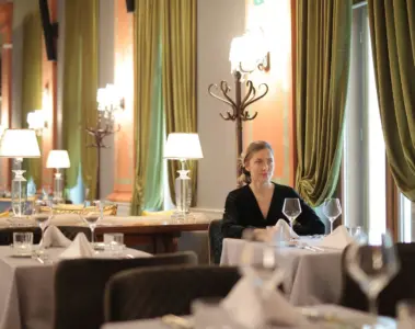 Woman seated alone at a carefully set restaurant table
