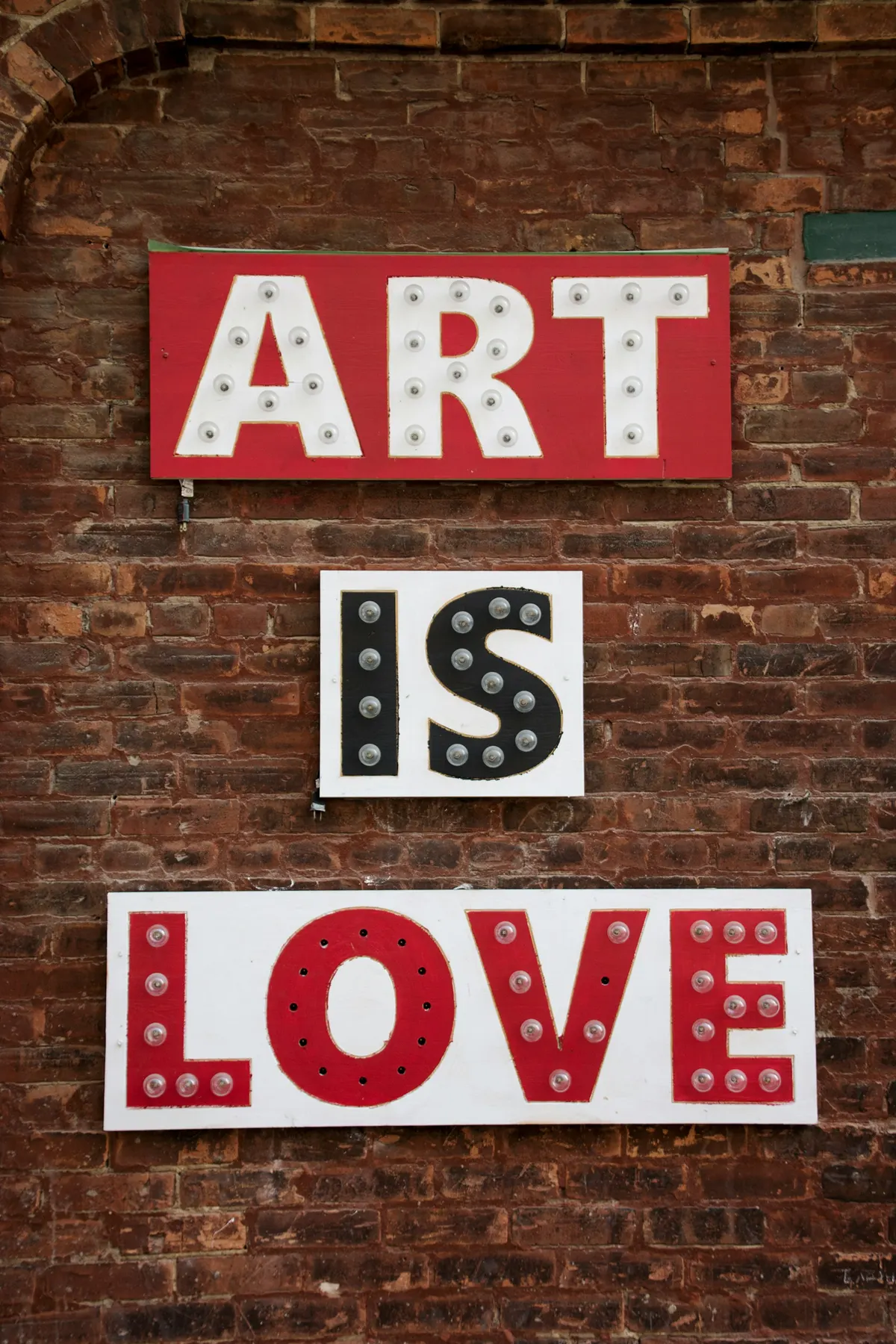 Art Is Love sign on a brick wall in Toronto's Distillery District