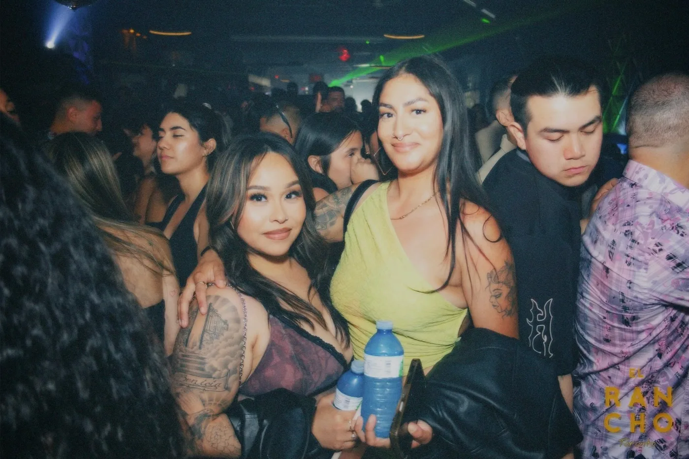 People dance together under club lights at El Rancho Toronto.