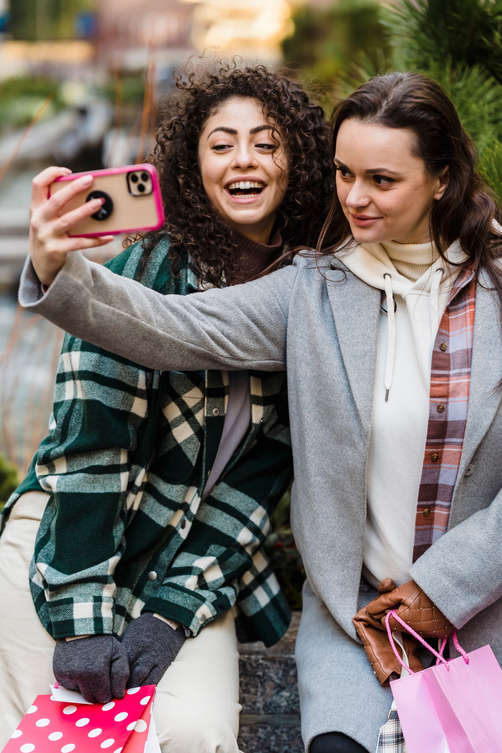 Two women taking a cheerful selfie after shopping
