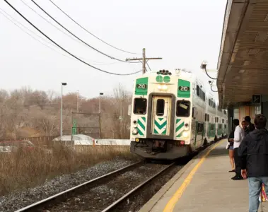 People waiting beside a GO train at Port Credit GO Station