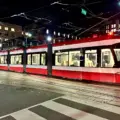 Red and white TTC streetcar at Spadina Avenue and King Street at night