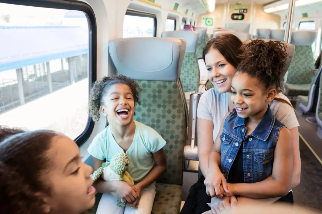 Family laughing together inside a GO train on a day trip