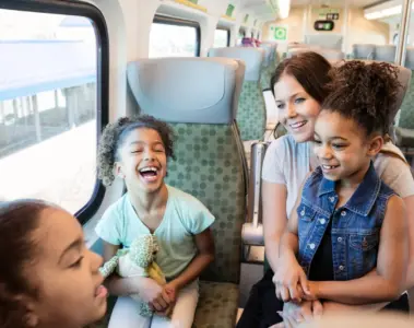 Family laughing together inside a GO train on a day trip
