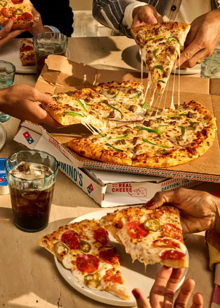 Friends sharing a hand-tossed Domino's pizza