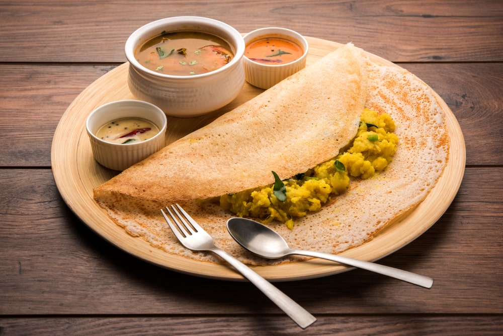 A South Indian masala dosa served with sambar and chutneys
