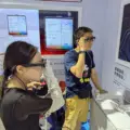 A woman and a man trying camera-equipped smart glasses at a technology exhibition