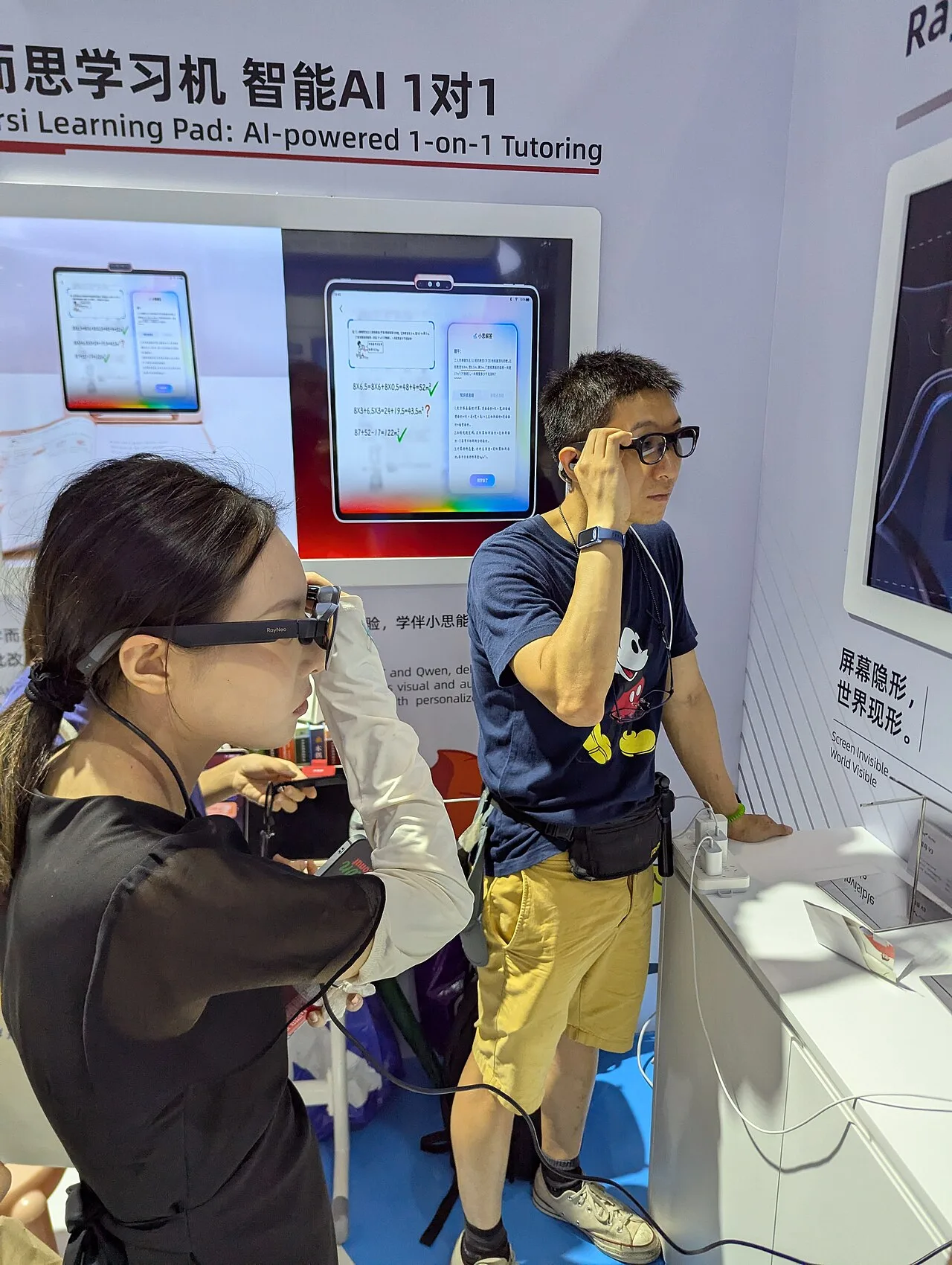 A woman and a man trying camera-equipped smart glasses at a technology exhibition