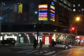 Toronto transit and pedestrians near College Street at night