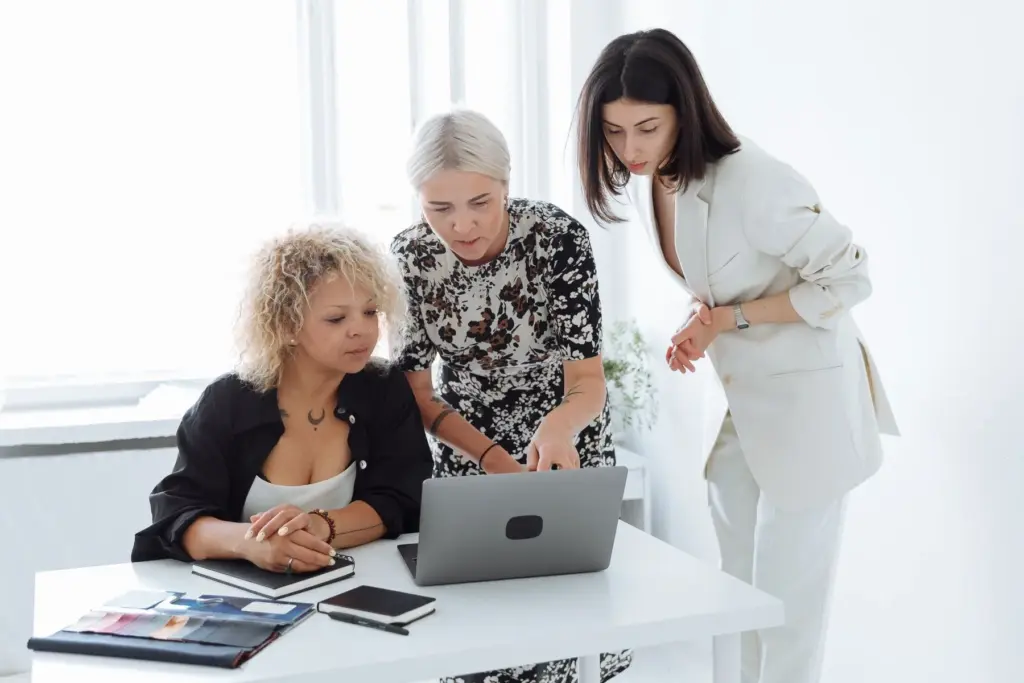 A group of women having a workplace discussion around a laptop