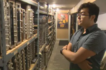 Tonality Records owner beside shelves of vintage audio receivers