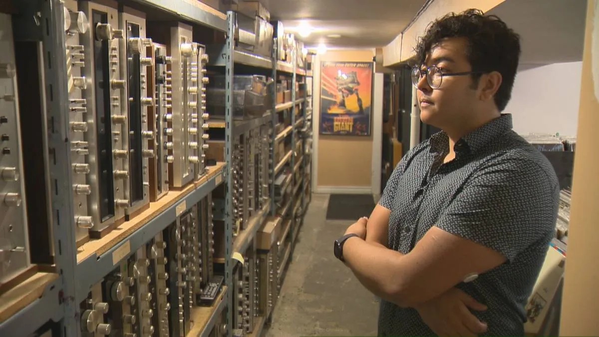 Tonality Records owner beside shelves of vintage audio receivers
