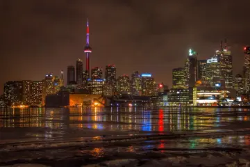 Toronto skyline and tall condo towers reflected in the water at night