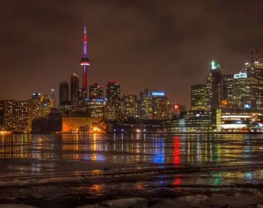 Toronto skyline and tall condo towers reflected in the water at night