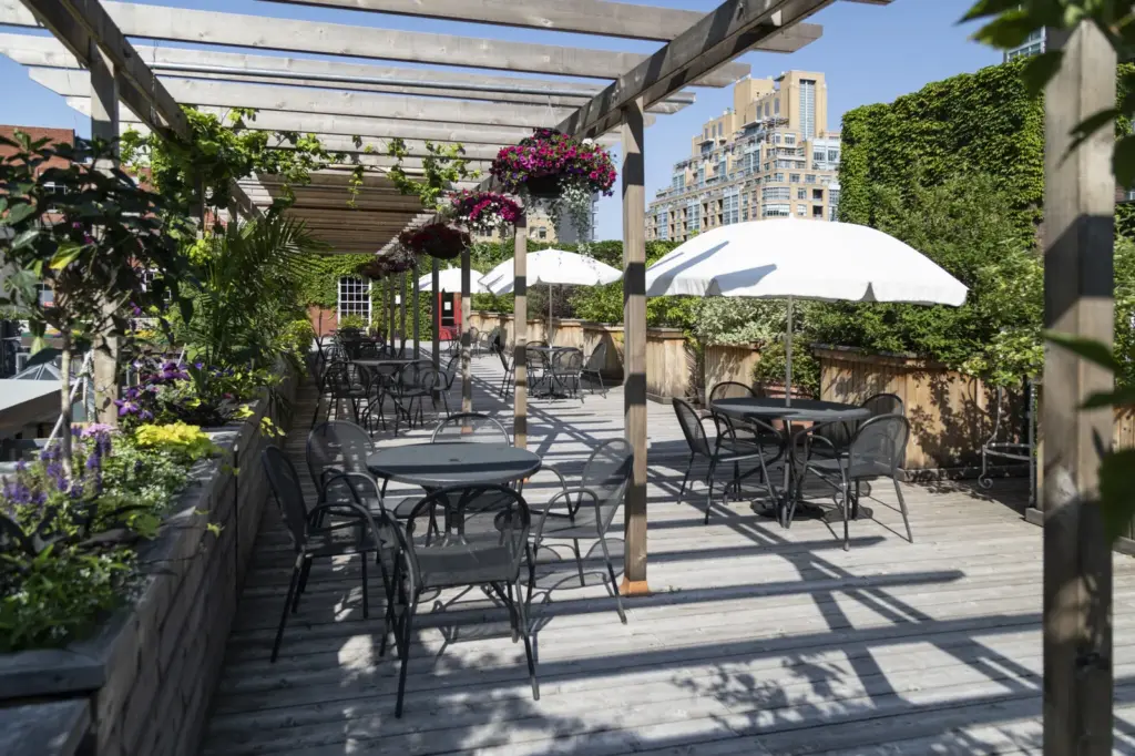 Tables under a pergola in the rooftop garden at 401 Richmond