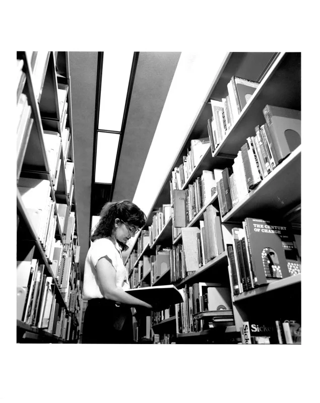 A woman standing between book stacks in the AGO library