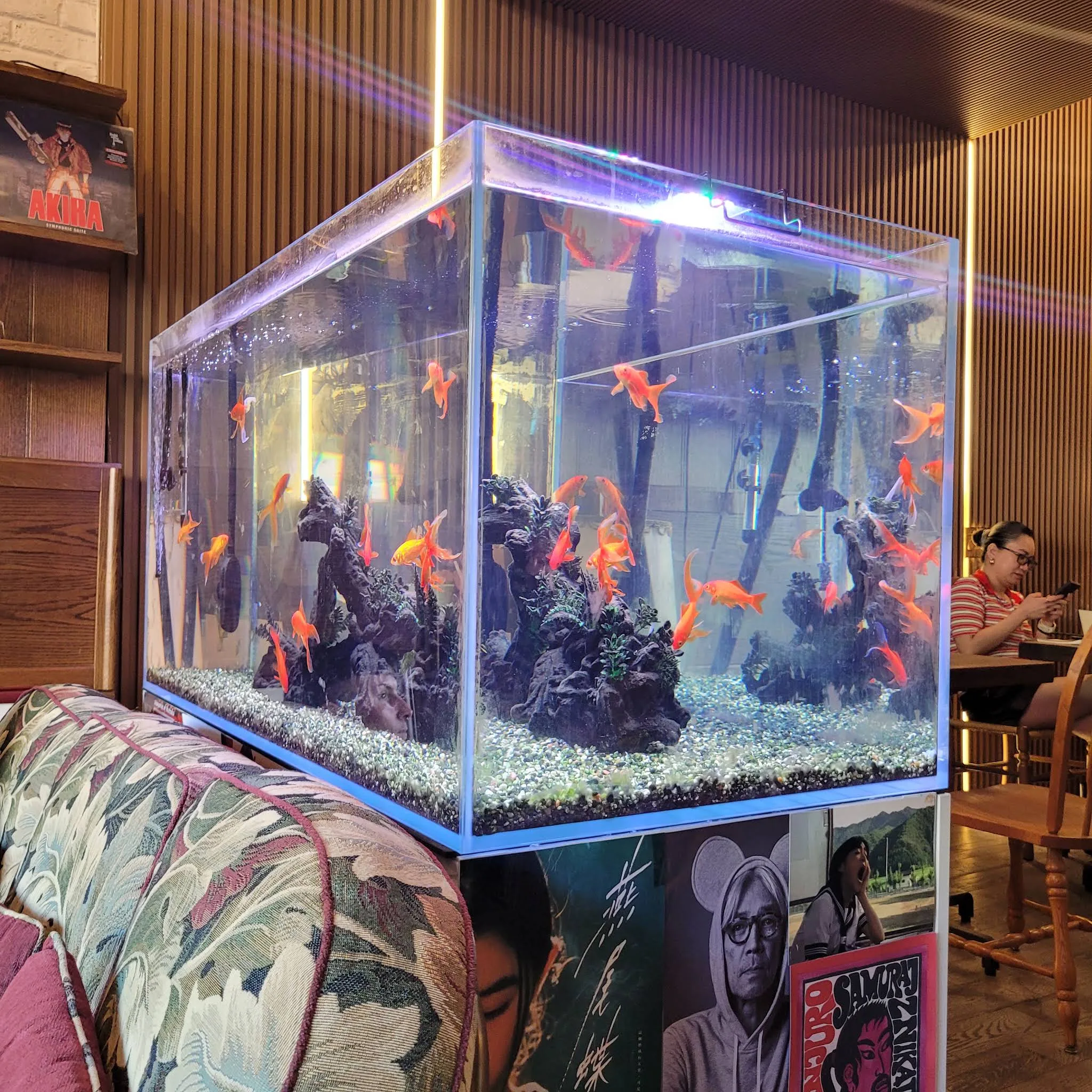 Illuminated aquarium and wood-panelled seating inside Lost in Toronto bar.