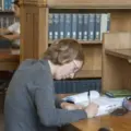 A reader working at a table inside Caven Library at Knox College
