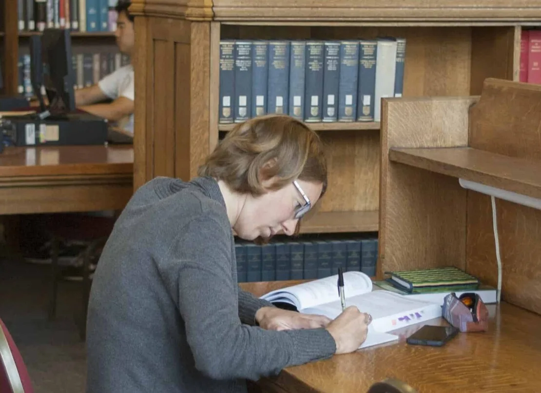 A reader working at a table inside Caven Library at Knox College