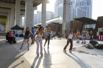 People gathering and roller skating at a summer event under the Gardiner in Toronto